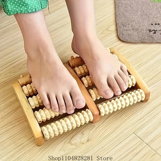 Person using a wooden foot massager on a wooden floor.